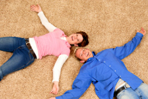 a man and woman laying on a clean carpet